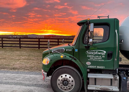 A picture of a propane delivery truck is featured against a stunning sunset.