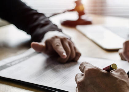 Hands mull over a legal document, showcasing the importance of indemnification clauses
