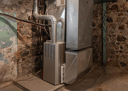 A furnace is pictured in a basement.