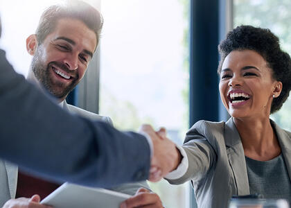 A businesswomen reaches out to shake hands while smiling, symbolizing a healthy fractional relationship.