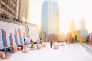 Miniature people: business man standing with stack of coins, lap to represent understanding propane insurance coverage