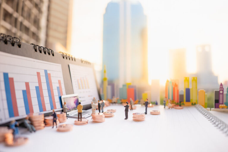Miniature people: business man standing with stack of coins, lap to represent understanding propane insurance coverage