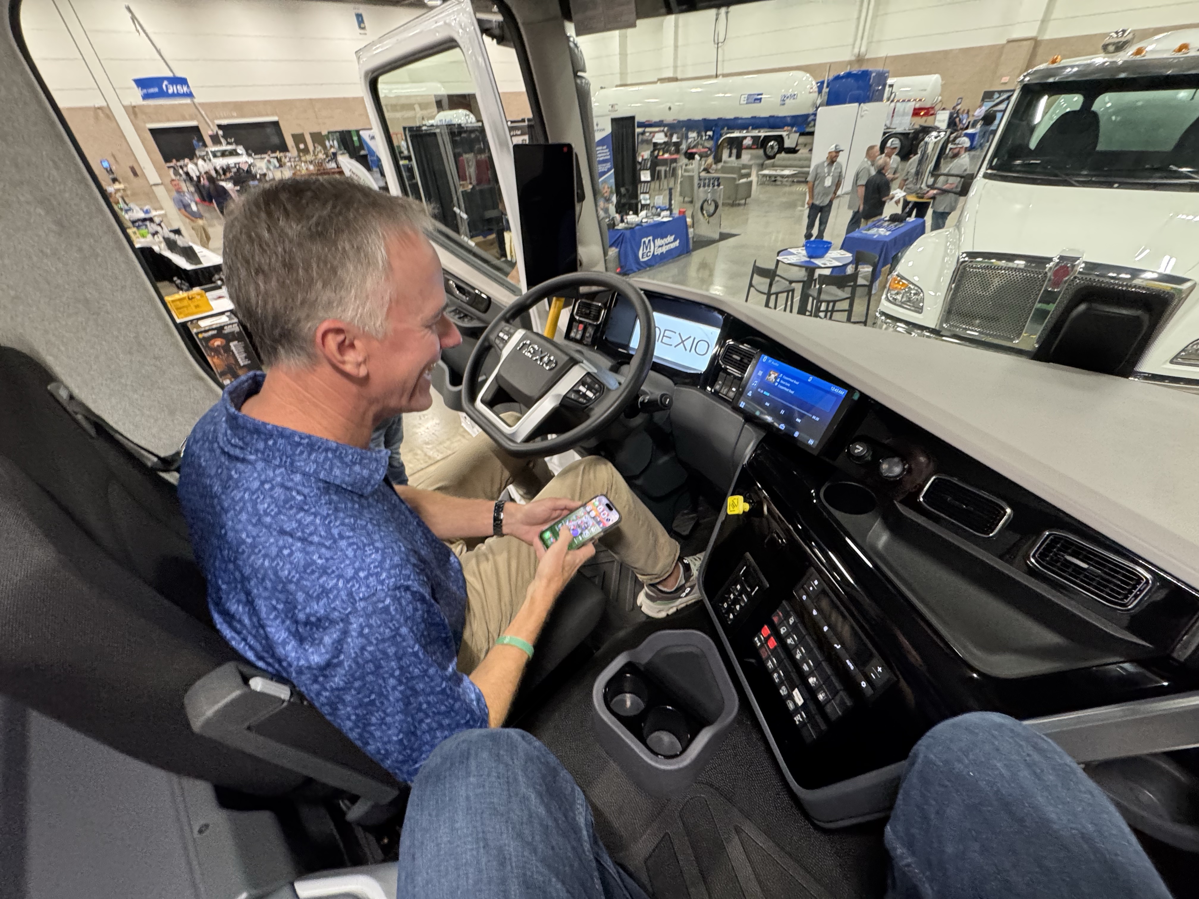 An expo attendee sits inside the cab of Nexio's Class 7 propane truck